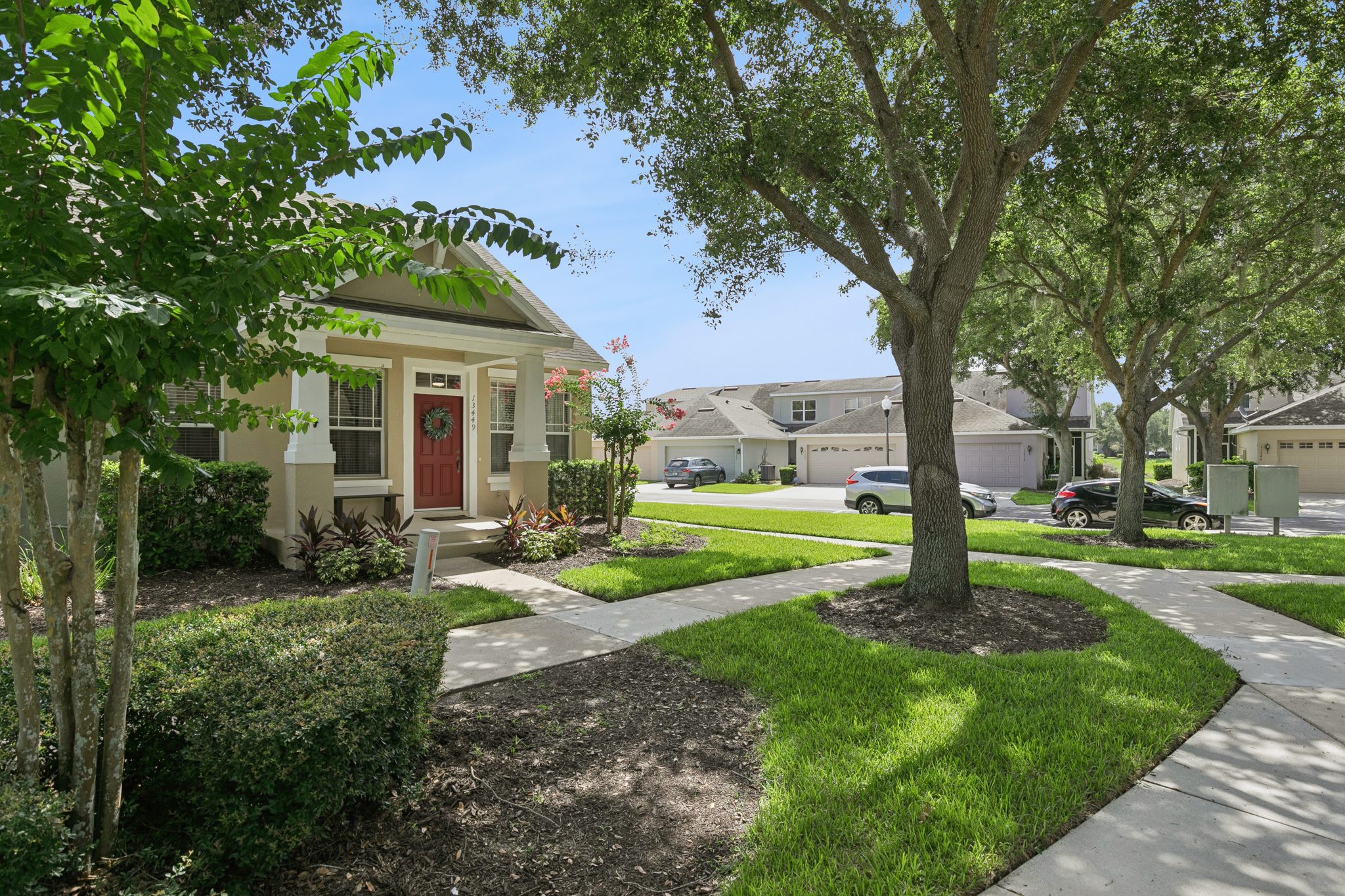 Streetscape view of the townhome along the community's manicured sidewalks at 13449 Carroway St, Windermere