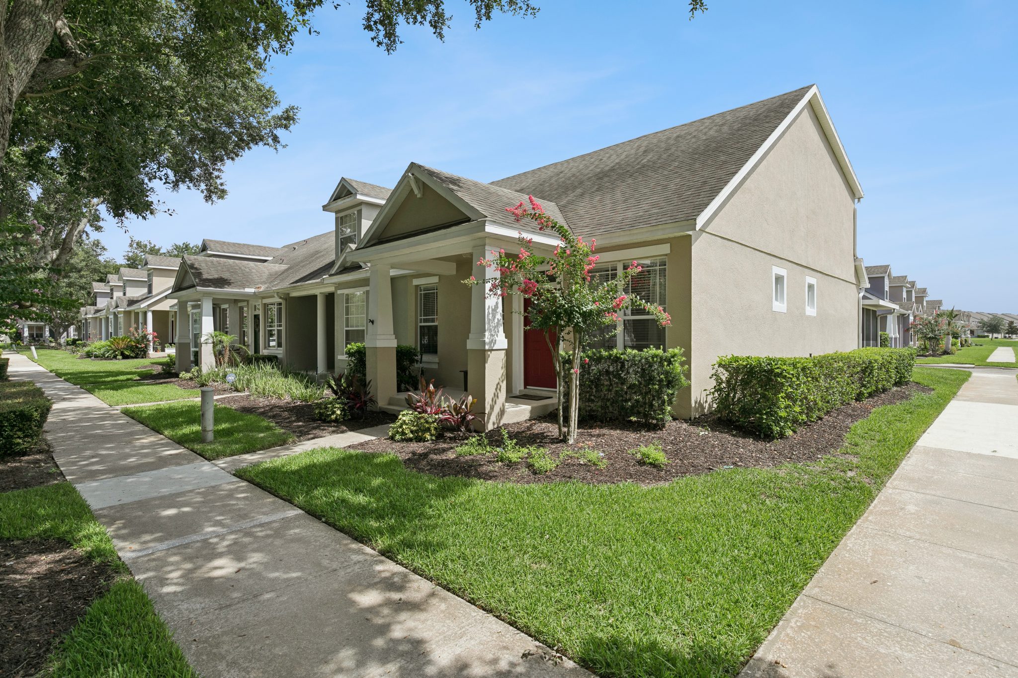 Front elevation set among mature oak trees in Merrick Landing at 13449 Carroway St, Windermere