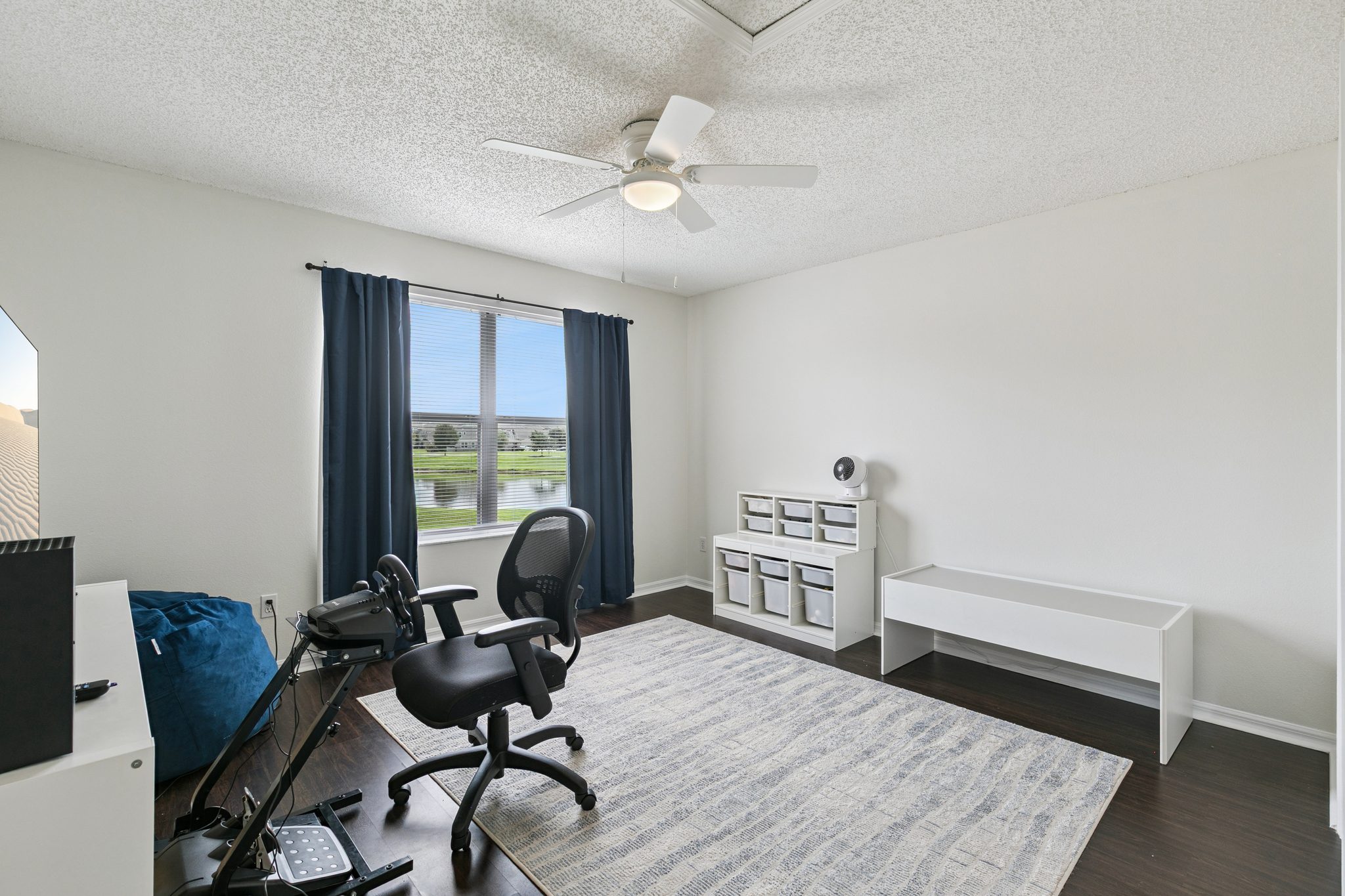 Flexible main-floor bedroom, shown as a home office with backyard views at 13449 Carroway St, Windermere
