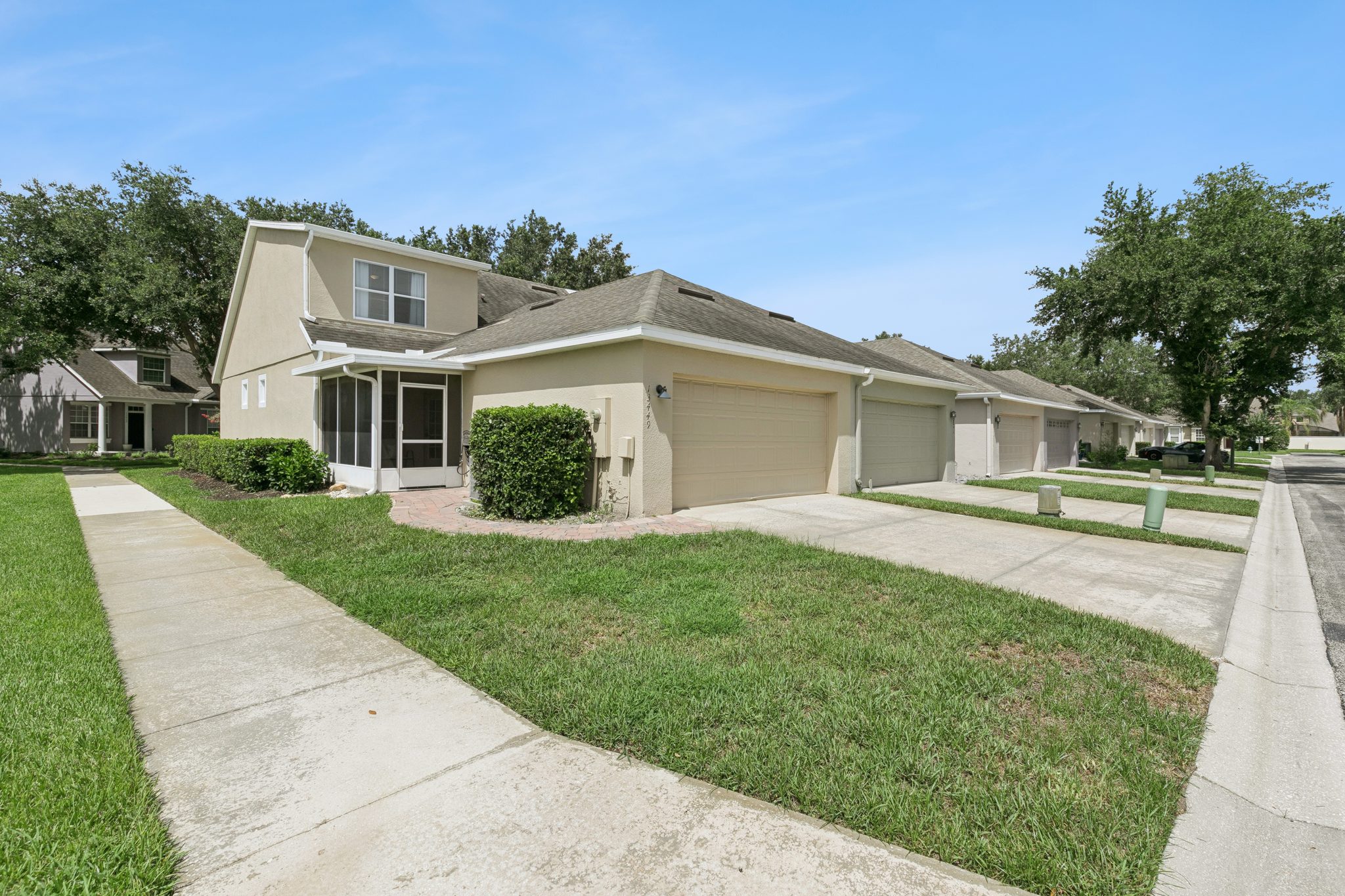 Rear exterior with the attached one-car garage and driveway at 13449 Carroway St, Windermere
