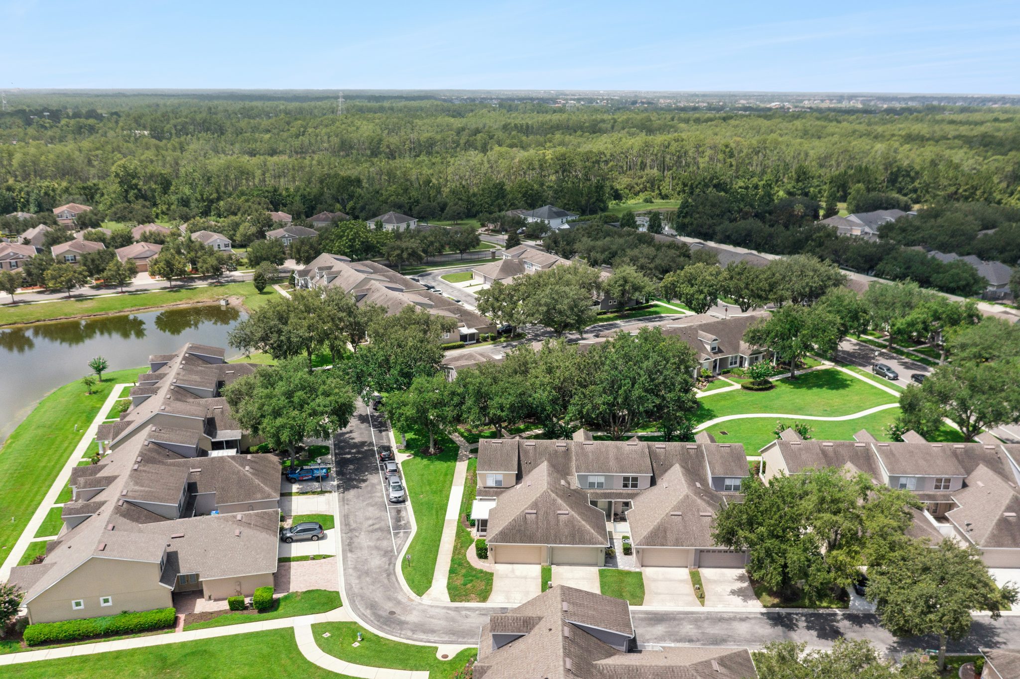 Aerial of the community rooftops beside a tranquil pond at 13449 Carroway St, Windermere