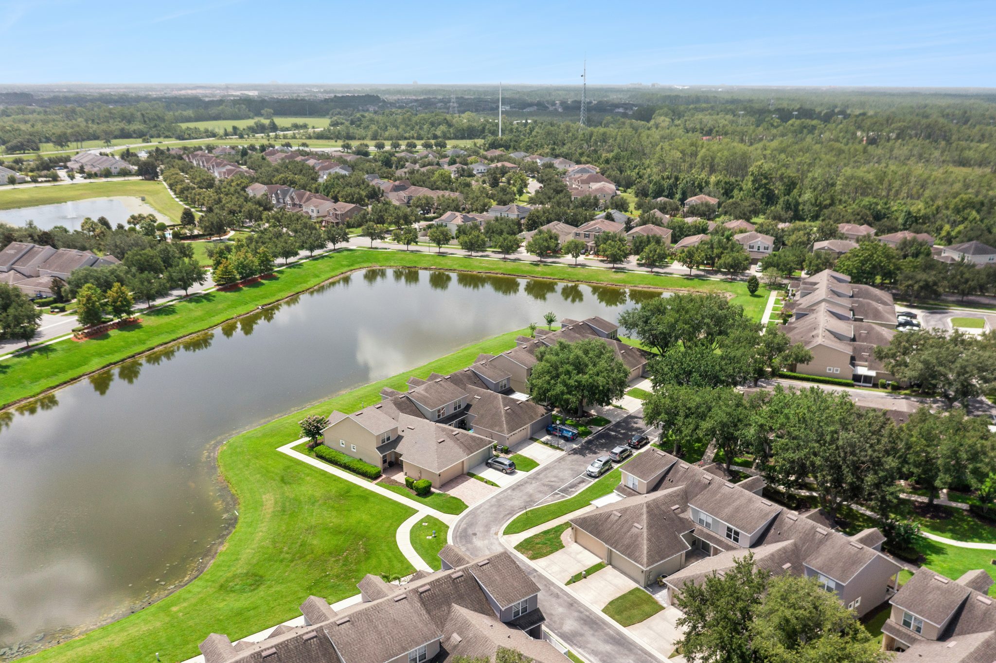 Aerial over Merrick Landing's ponds and tree-lined streets at 13449 Carroway St, Windermere