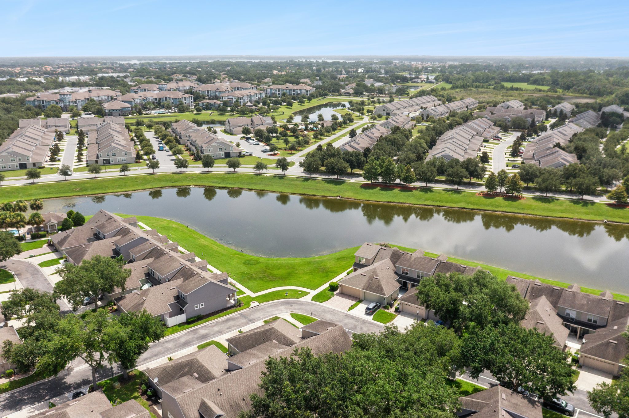 Wide aerial of the Merrick Landing community and its lake at 13449 Carroway St, Windermere